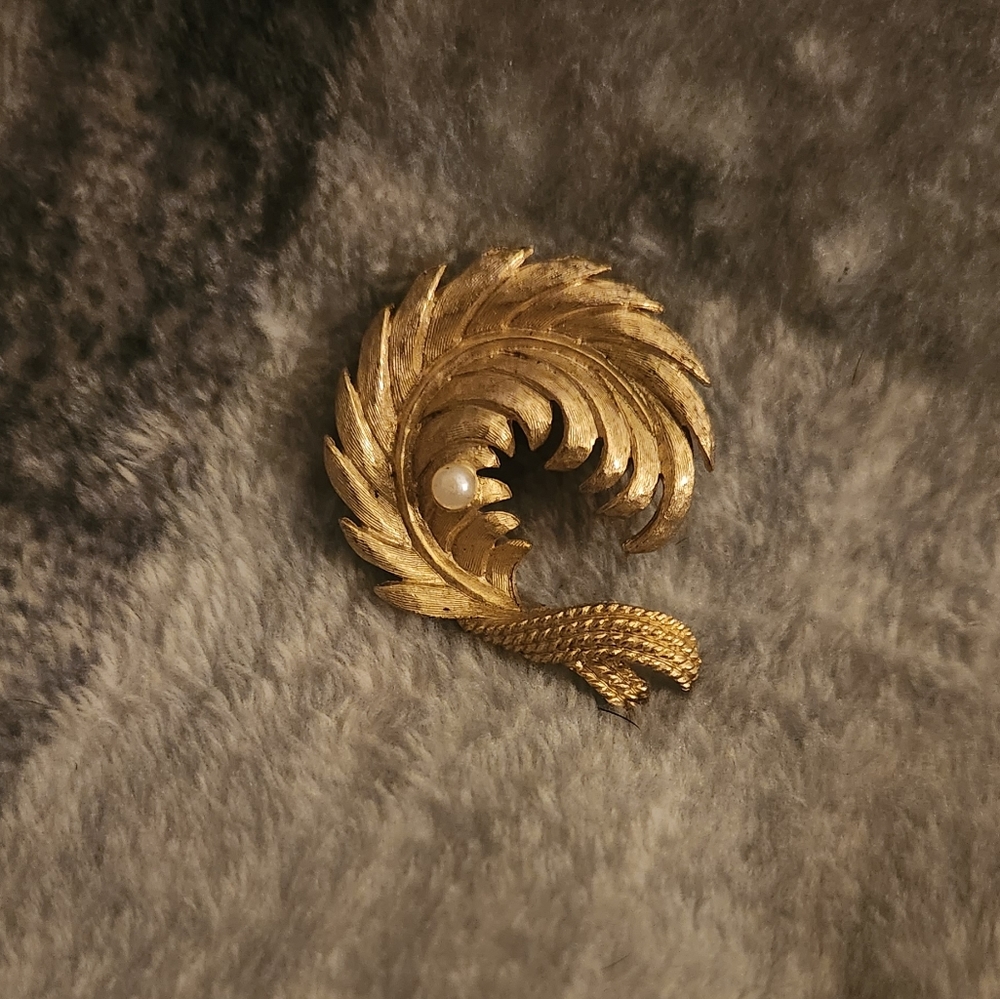 Simple gold colored pin with white stone